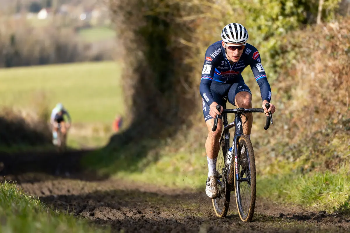 Cycliste en tenue de course sur un chemin boueux, compétition de cyclo-cross en nature.