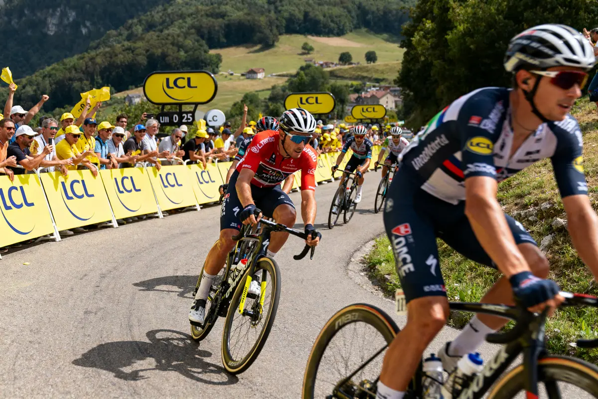Des cyclistes participent à une course, entourés de spectateurs enthousiastes et de panneaux LCL.