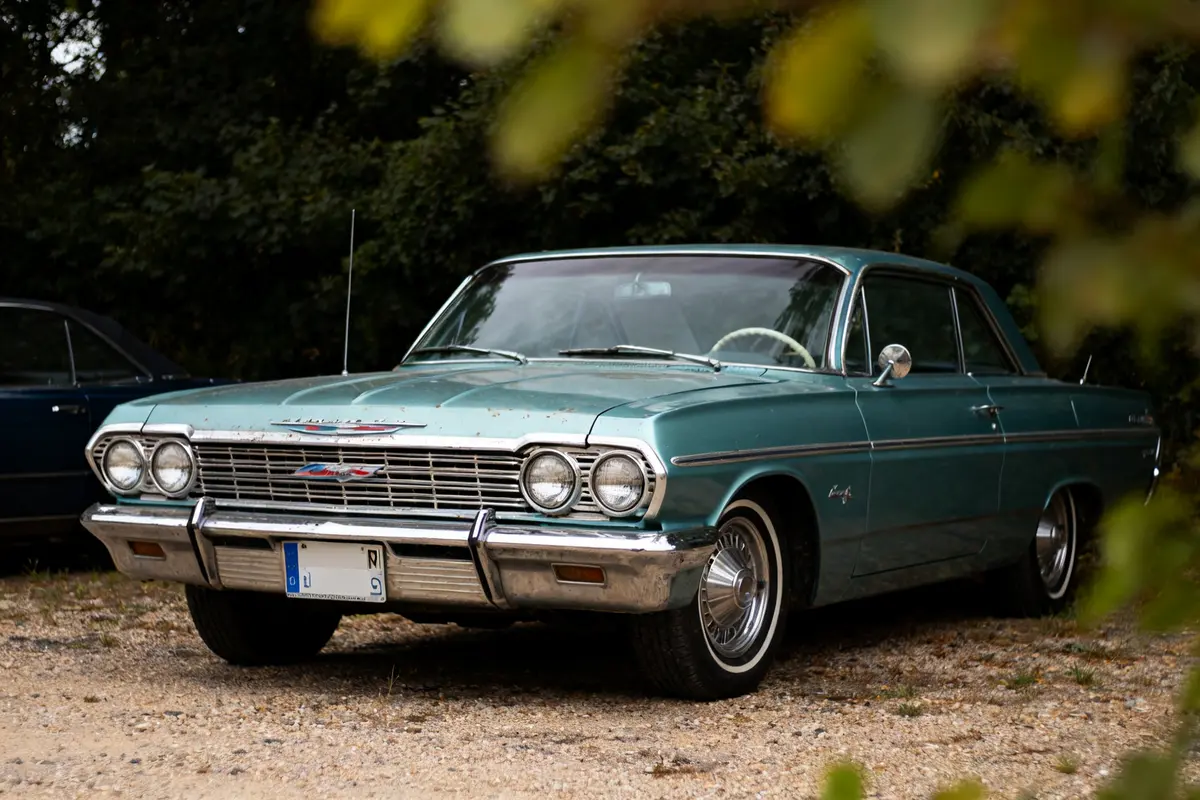 Voiture classique verte stationnée, modèle vintage 64 impala car dans un cadre naturel