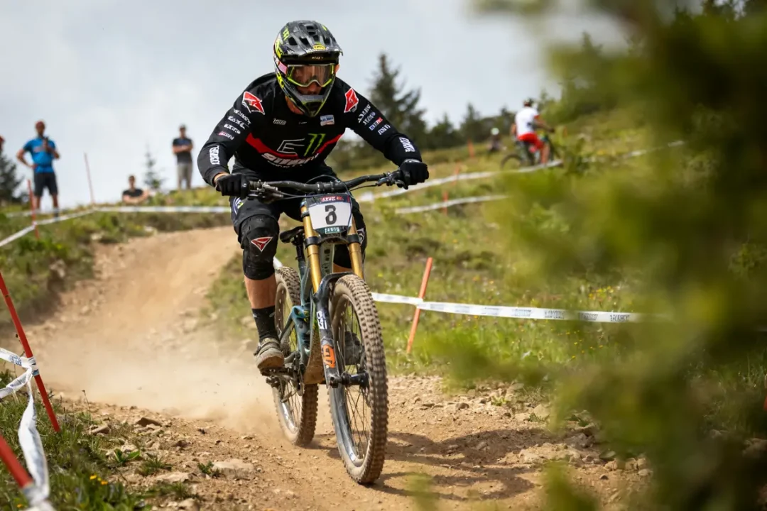Amaury Pierron en course de descente VTT sur piste montagneuse avec spectateurs en arrière-plan