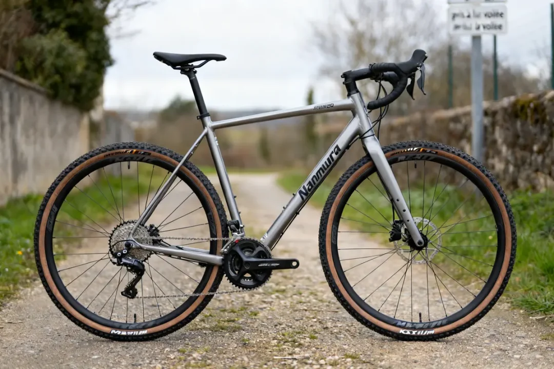 Vélo Nakamura Allroad 250 sur chemin gravillonné en extérieur avec pneus tout-terrain.