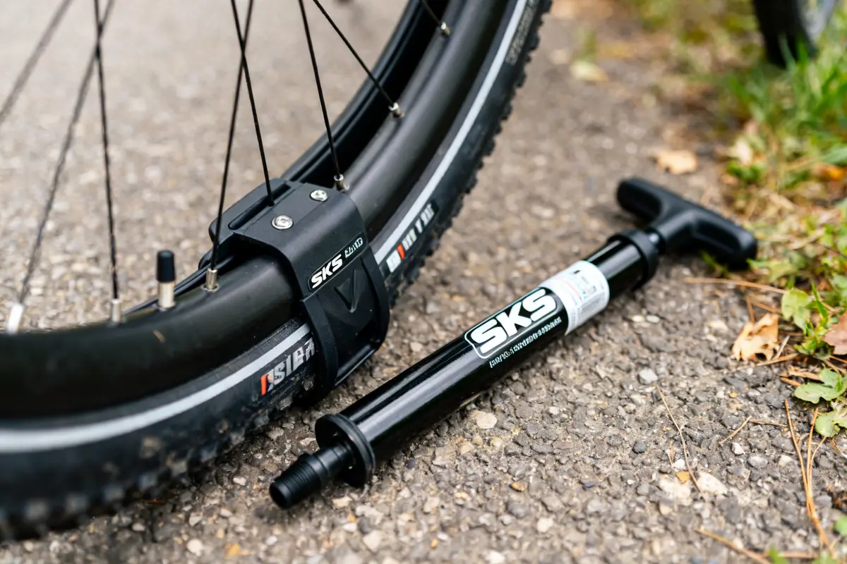 Pompe à vélo SKS près d'une roue sur une surface asphaltée