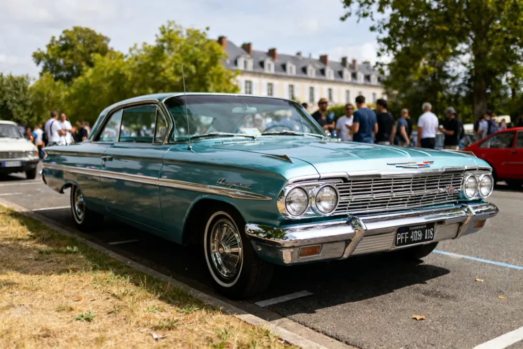 Voiture classique bleu-vert chevy 1959 impala garée avec des gens en arrière-plan