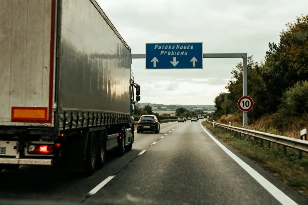 Camion roulant sur autoroute vers Poitiers, itineraire camion indiqué par panneau bleu.