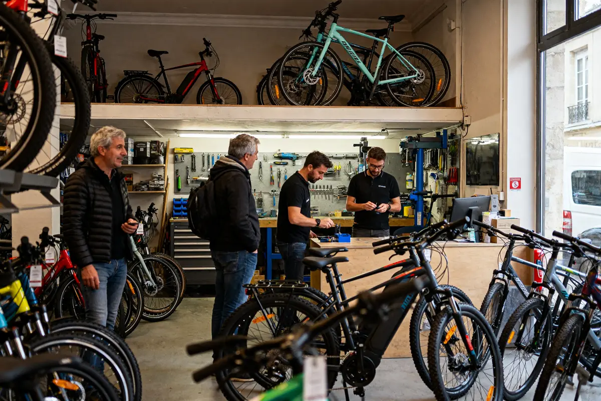 Magasin de vélos animé avec clients et employés chez Culture Vélo à Brest