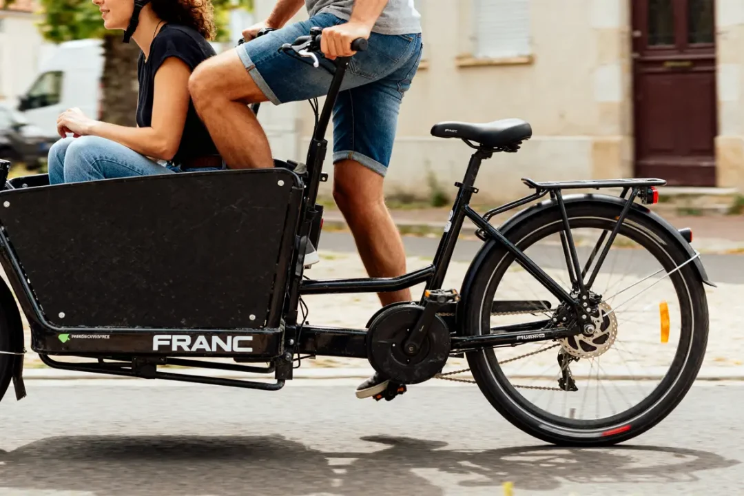 Personnes utilisant un vélo électrique biplace adapté pour le transport en ville