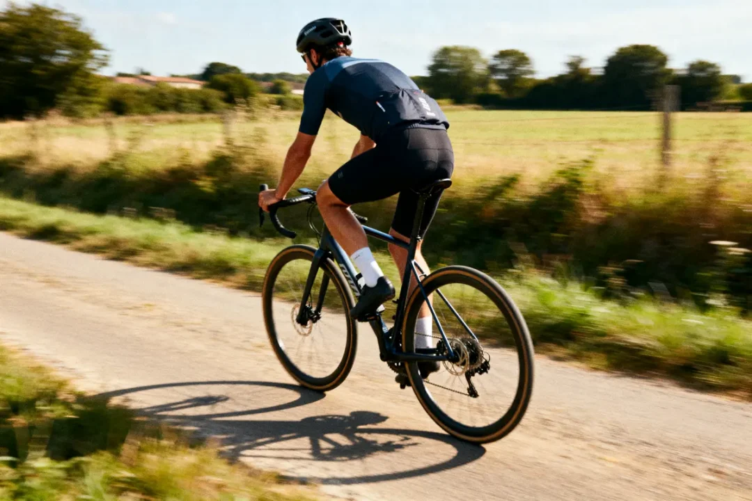 Cycliste sur route de campagne, analysant la vitesse moyenne en vélo pour performance optimale